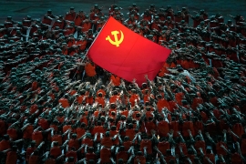 a dynamic performance around a red flag emblazoned with a sickle and hammer