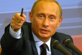 Vladimir Putin at a microphone.
