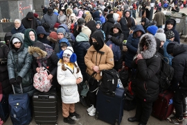 Hundreds of Ukraine evacuees, mostly women and children, wait for a train that will take them to Poland