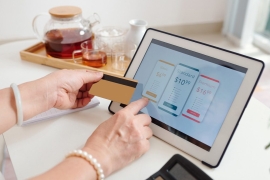 Hands of senior woman choosing subscription or payment plan on tablet computer and paying with credit card