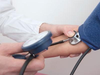 health care provider using stethoscope to read blood pressure