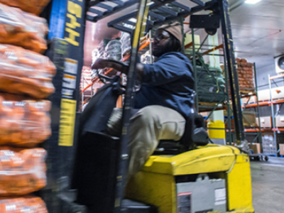 Forklift driver in food warehouse.