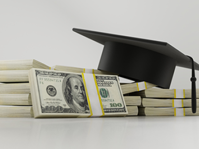graduation cap and stacks of $100 bills