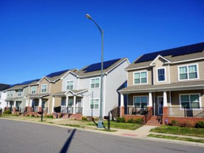 row of houses with solar panels on the roofs