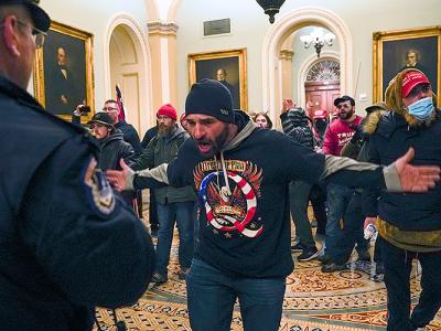 One of the militants who broke into the US Capitol gestures toward police officer