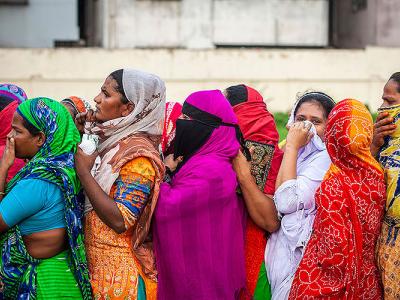 women in Bangladesh in a crowded line await COVID-relief aid
