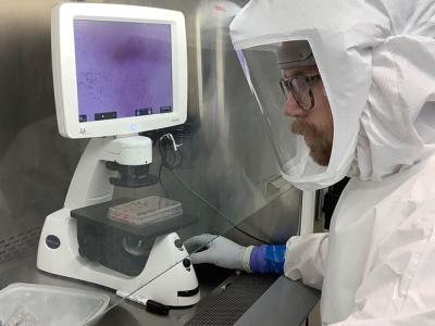 person in Hazmat suit working in lab