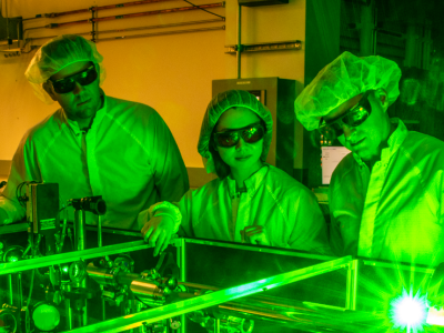 Berkeley Lab doctoral student Fumika Isono (center), BELLA Center Deputy Director Jeroen van Tilborg (right), and research scientist Sam Barber set up a novel laser stabilization experiment at one of the BELLA Center’s 100-TW-class lasers.