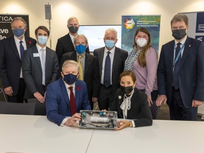 masked scientists and policymakers gathered around GHG sensor