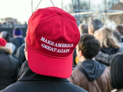 man wearing backward red Make America Great Again hat