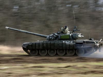 A Russian tank races across a field during training exercises in Russian lands adjacent to the Ukraine border