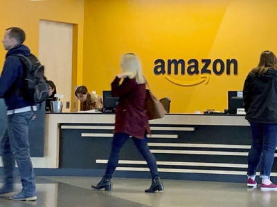 people walking in foreground of an Amazon front desk