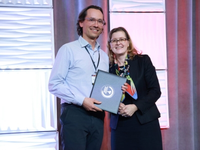 image of two people smiling and posing holding an award