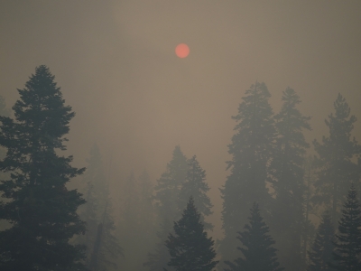 A dot of an orange sun is visible through thick smoke generated by the Caldor Fire in South Lake Tahoe in 2021. Researchers are studying how smoke from fires like this can cause long-term health effects.