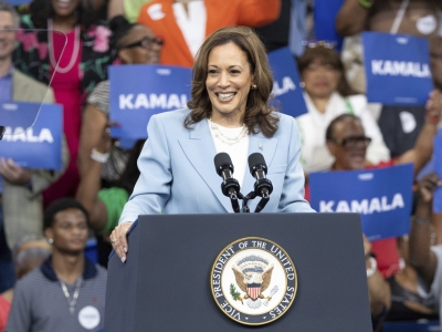 Kamala Harris speaking at a campaign rally in Atlanta, Georgia, with a crowd of people cheering behind her.