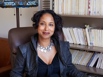 person sitting in a chair in front of a bookshelf