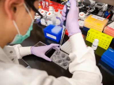 image of scientist pipetting in lab