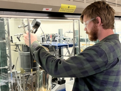 image of someone working in a research lab, under a fumehood