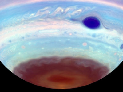the southern portion of a blue Jupiter with a dark blue spot and a chocolate-brown cap at the bottom