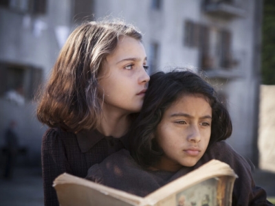 Two young girls sit closely together in this scene from the HBO series 