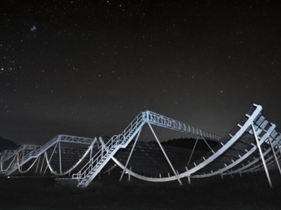 looping steel structure lit up against a starry sky