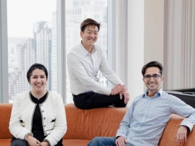 three people sitting on an orange couch