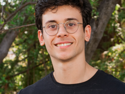 headshot of man in glasses smiling