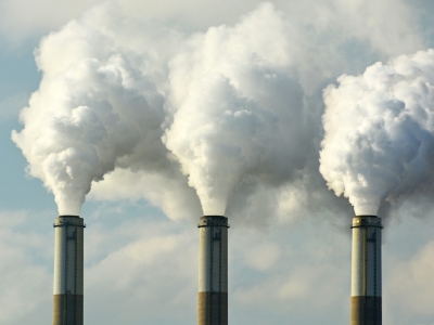 image of three industrial chimneys pumping out clouds of smoke