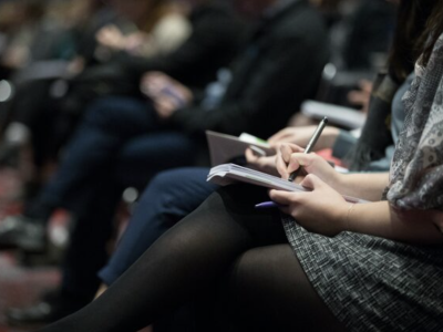 image of someone holding a notebook in their lap and writing in it