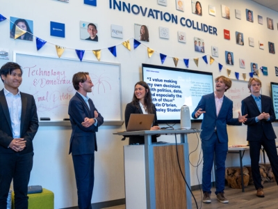 People standing in front of a room deliver a closing pitch about the platform SimpleGov.