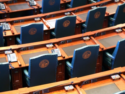 arcing rows of empty chairs in a legislative chamber