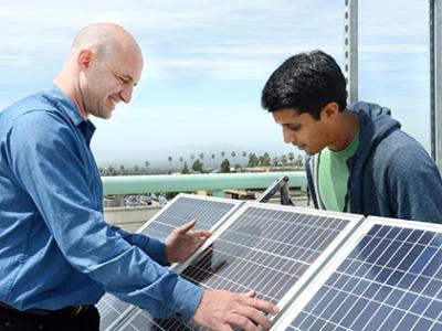 Eric Brewer and graduate student inspect solar panel.