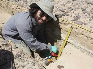 an image of aj white examining an archaeological dig 