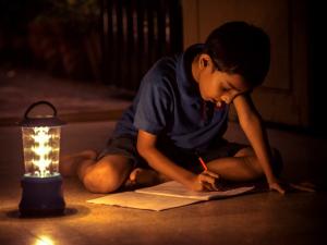 A boy studies by a solar lamp 