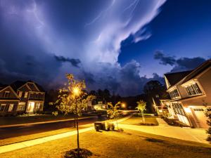 Powerful lightning storm front passes over residential houses