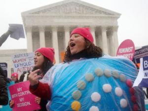 A woman wears a birth control pill costume amid a sea of protesters as she protests in front of the Supreme Court in Washington D.C.. 