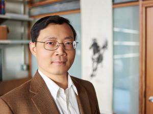 Junqiao Wu looks at the camera while standing in his lab
