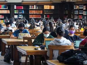 Students in masks work at tables in Doe Libary's North Reading room on the first day of classes, fall 2021.