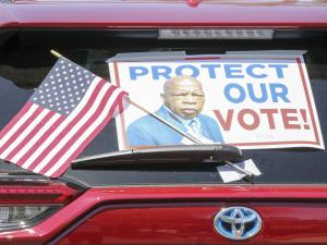 A car waits in line at the John Lewis Voter Advancement Day Votorcade