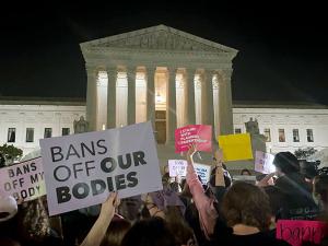 Pro-choice protesters hold signs outside the US Supreme Court building in Washington, D.C., the night the draft decision to overturn abortion rights was released