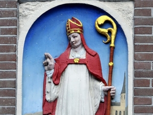 Stone tablet depicting Saint Nicholas with a scepter, and red and white garments depicting a Catholic bishop.