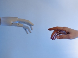 image of a robot hand meeting a human hand from opposite sides