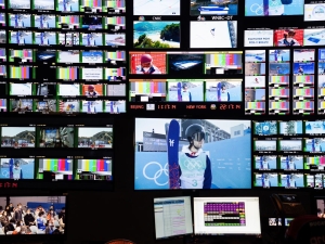 dozens of tv screens showing various sporting events from the control room of the Beijing Olympics