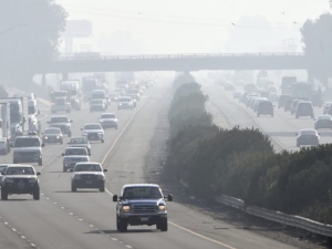 Cars drive through smoggy air on a California highway
