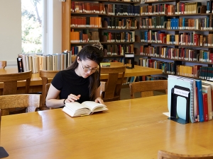 image of woman reading a book at the library