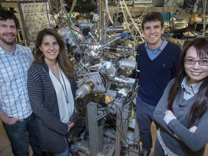 image of 4 people standing in front of a machine in a lab