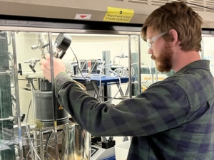 image of someone working in a research lab, under a fumehood