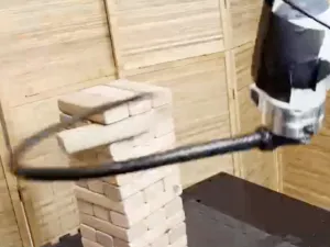 image of robot hand whipping Jenga blocks