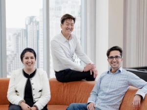 three people sitting on an orange couch