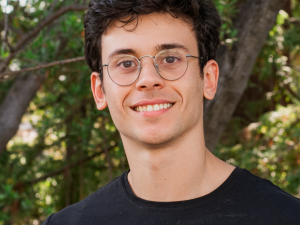 headshot of man in glasses smiling